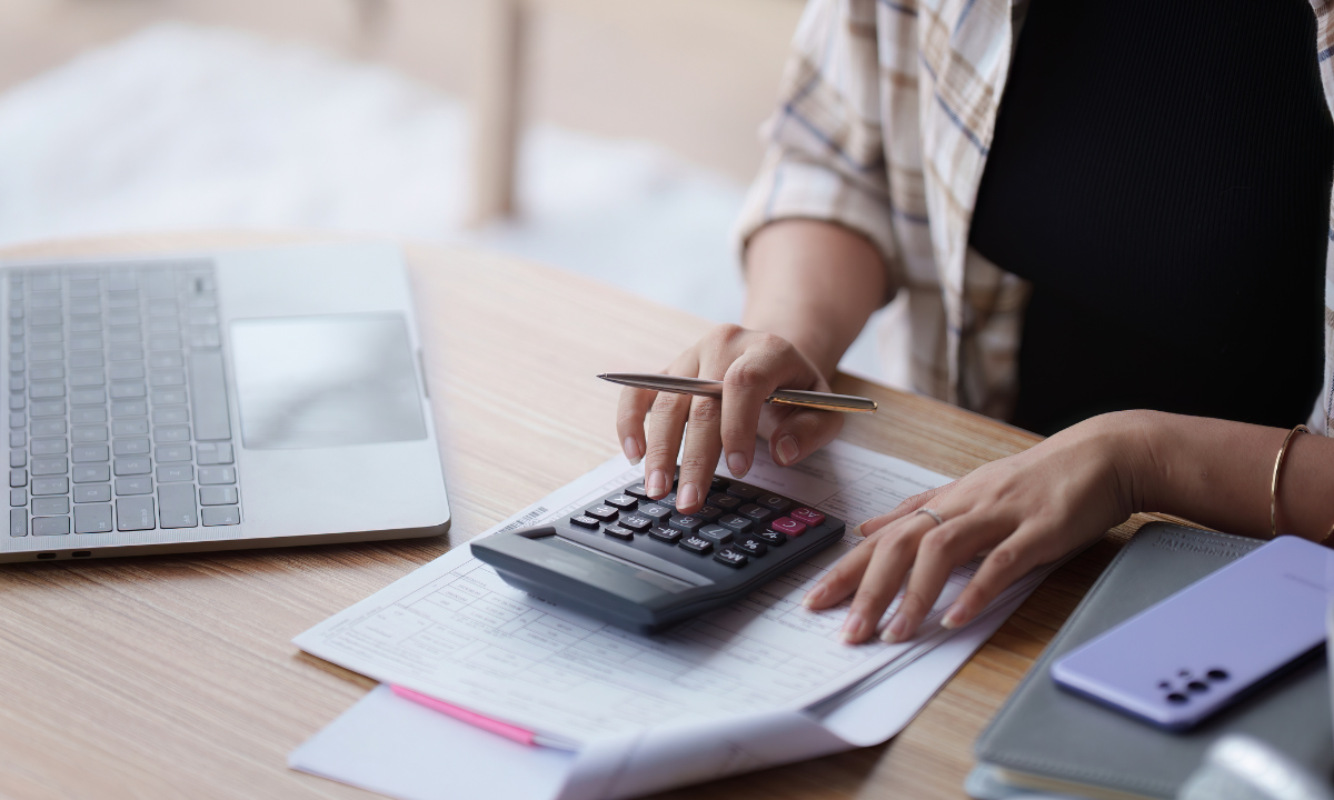 Hombre con calculadora revisa los gastos para vender un piso en Madrid que tiene que pagar